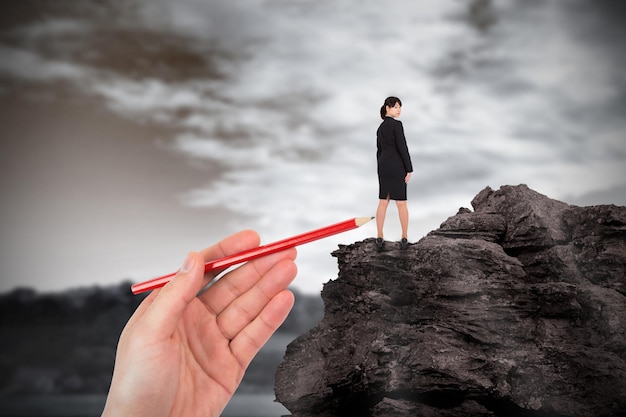 Photo composite image of hand drawing businesswoman against large rock overlooking foggy forest