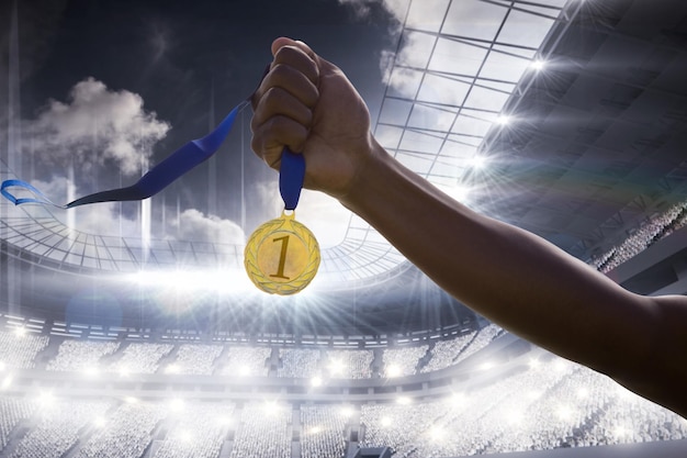 Composite image of hand holding a gold medal on white background