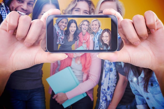 Composite image of hand holding smartphone showing