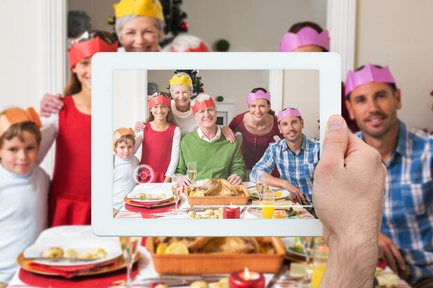 Composite image of hand holding tablet pc