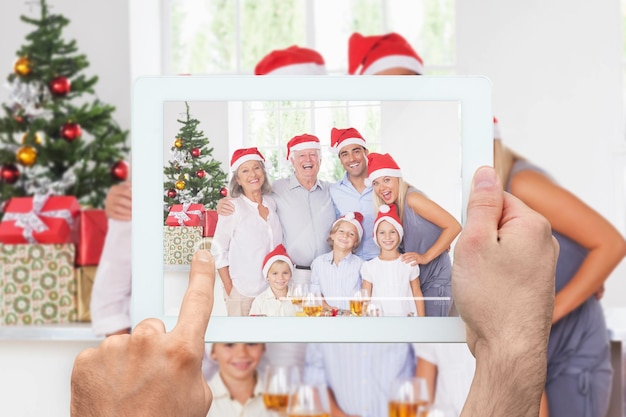 Composite image of hand holding tablet pc