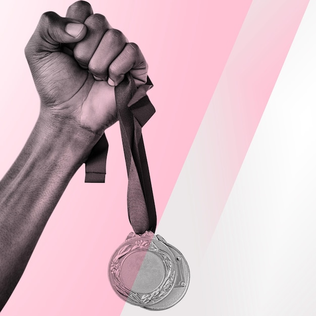 Composite image of hand holding two gold medals on white background