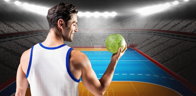 Composite image of happy athlete male holding a ball