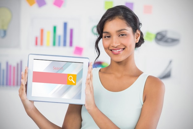 Composite image of happy businesswoman showing digital tablet in creative office