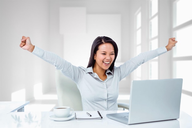 Composite image of happy businesswoman with raised arms