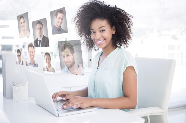 Composite image of happy businesswoman working on her laptop