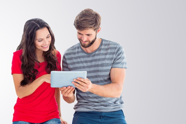 Composite image of happy couple using tablet