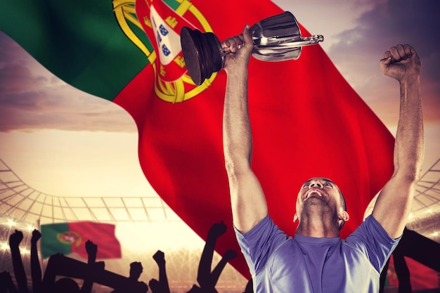 Composite image of happy rugby player holding trophy