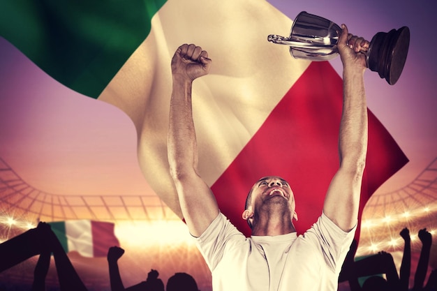 Composite image of happy rugby player holding trophy