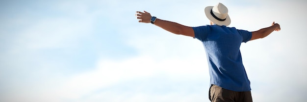 Composite image of low angle of a man raising arms up