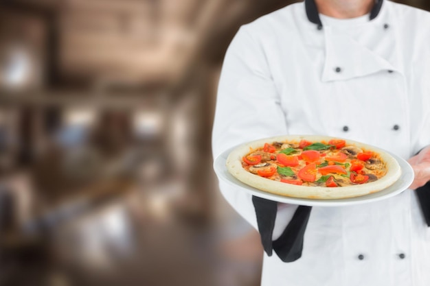 Composite image of male chef offering pizza