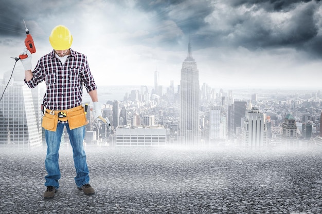 Composite image of male repairman holding drill machine and hammer