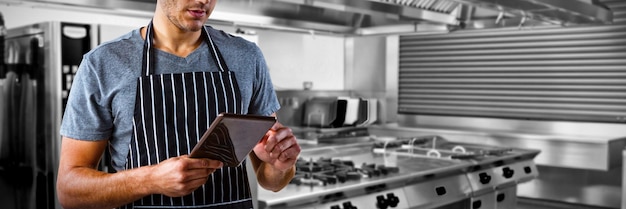 Composite image of male waiter using digital tablet