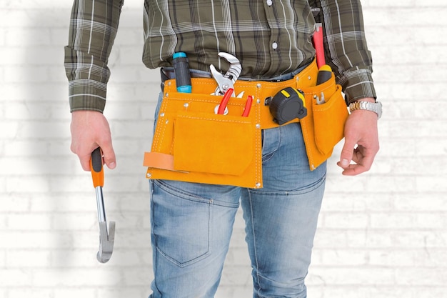 Composite image of manual worker holding hammer