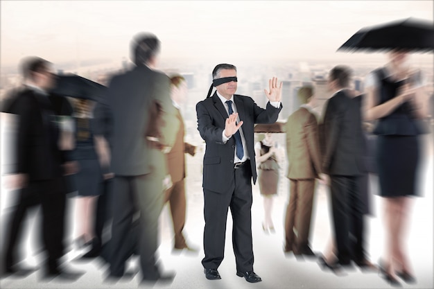 Composite image of mature businessman in a blindfold