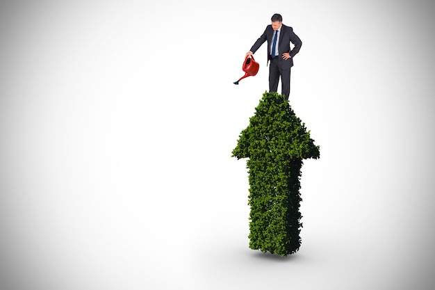 Composite image of mature businessman using watering can