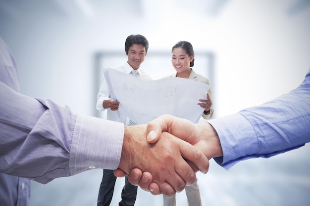 Composite image of men shaking hands