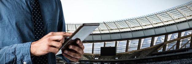 Composite image of mid-section of business man using a tablet