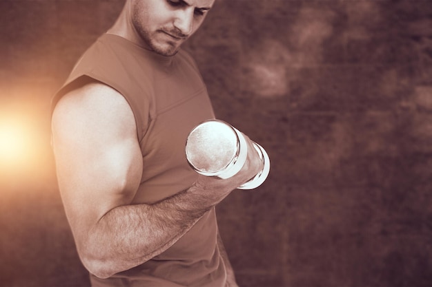 Foto immagine composita della sezione centrale di un giovane in forma che si esercita con i dumbbells