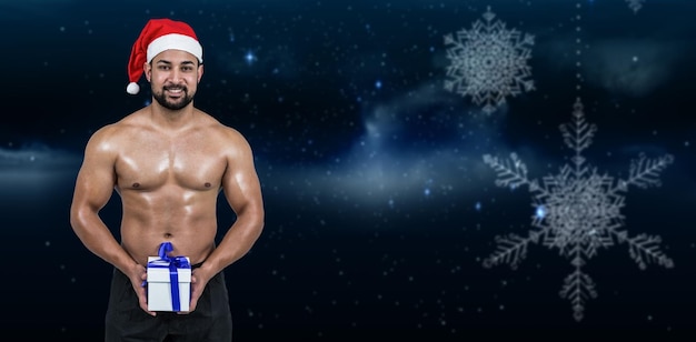 Composite image of muscular man in santa hat