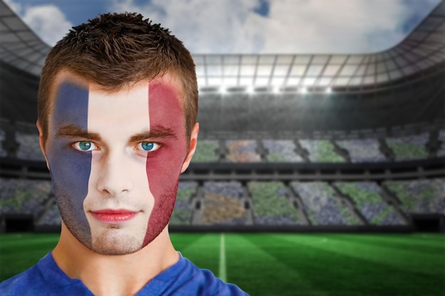 사진 스포트라이트 아래 대형 축구 경기장에 얼굴 페인트를 칠한 프랑스 축구 팬의 합성 이미지