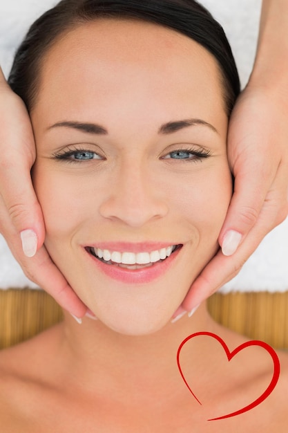 Composite image of peaceful brunette enjoying a facial massage