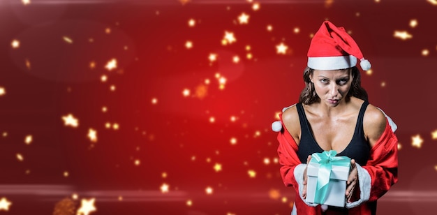 Composite image of portrait of athlete in christmas costume and holding present