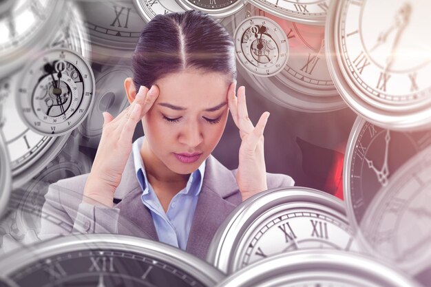 Composite image of portrait of a beautiful businesswoman having a headache