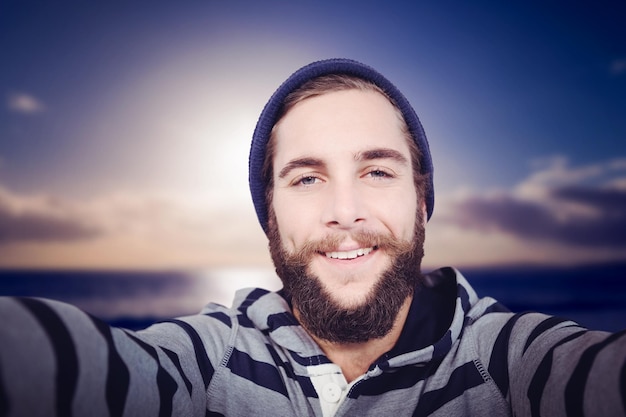 Composite image of portrait of happy hipster with hooded shirt