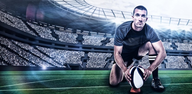 Composite image of portrait of rugby player in black jersey placing ball with 3d