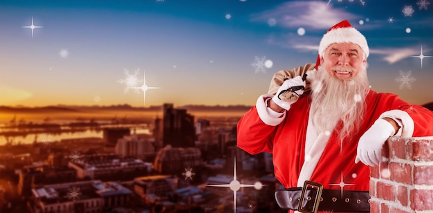 Composite image of portrait of santa claus carrying bag full of gifts