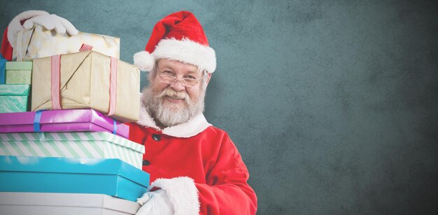 Composite image of portrait of santa claus holding christmas presents