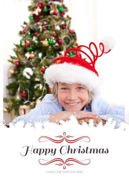 Composite image of portrait of a smiling boy wearing a christmas hat