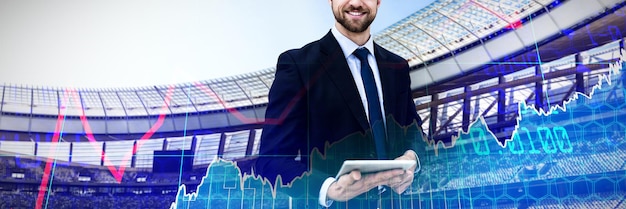 Composite image of portrait of smiling businessman holding digital tablet