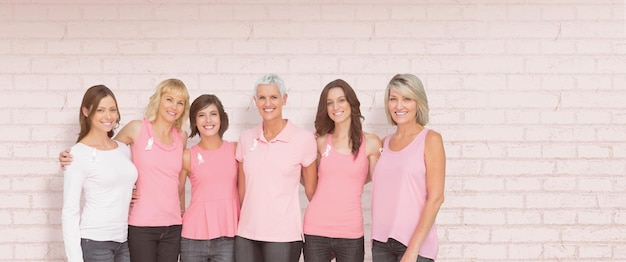 Composite image of portrait of smiling women supporting breast cancer social issue