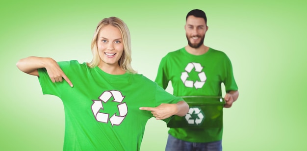 Composite image of portrait of woman pointing towards recycling symbol on tshirts