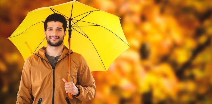 फोटो composite image of portrait of young man holding yellow umbrella