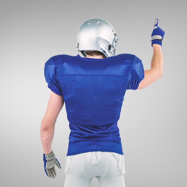 Composite image of rear view of american football player pointing