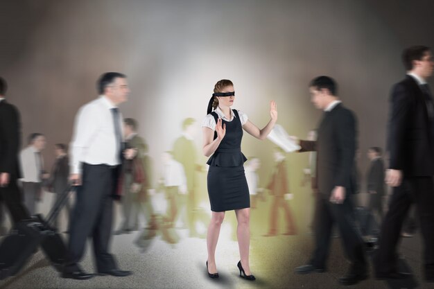 Composite image of redhead businesswoman in a blindfold