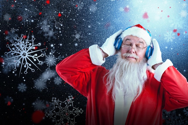 Composite image of santa claus listening to music on headphones with eye closed