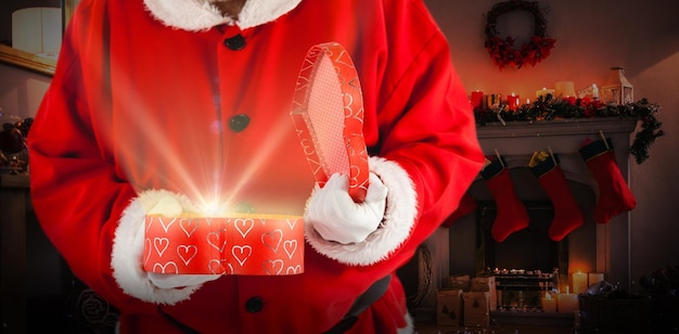 Composite image of santa claus opening a gift box