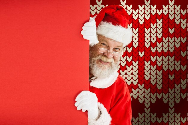 Composite image of santa claus peeking from red board