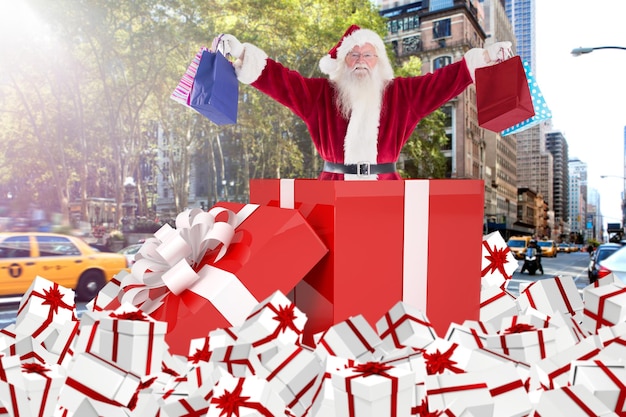 Photo composite image of santa standing in large gift against new york street