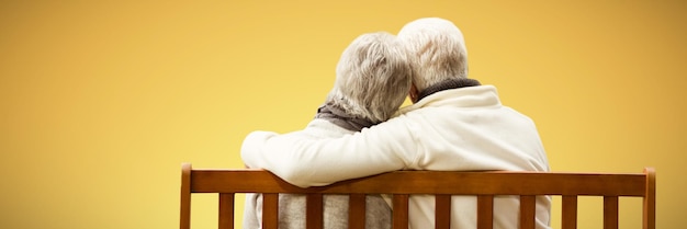 Composite image of  senior couple embracing on a bench