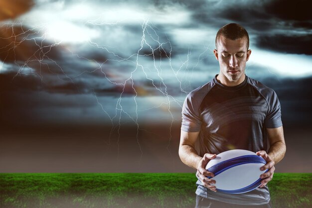 Composite image of serious rugby player holding ball