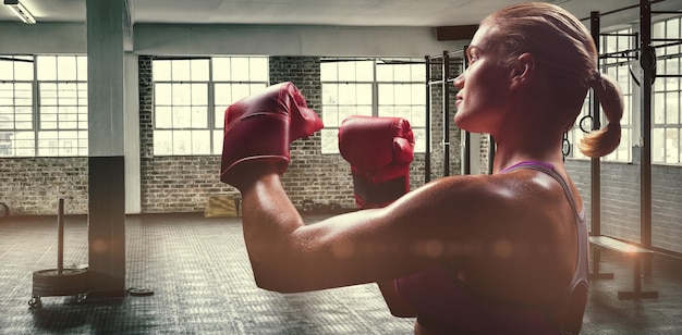 Composite image of side view of female boxer with fighting stance