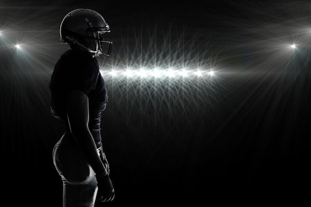 Composite image of side view of silhouette american football player standing