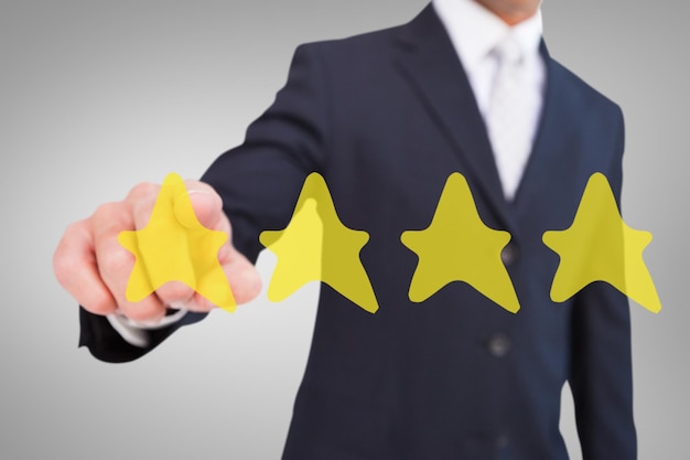 Composite image of smiling businessman in suit pointing