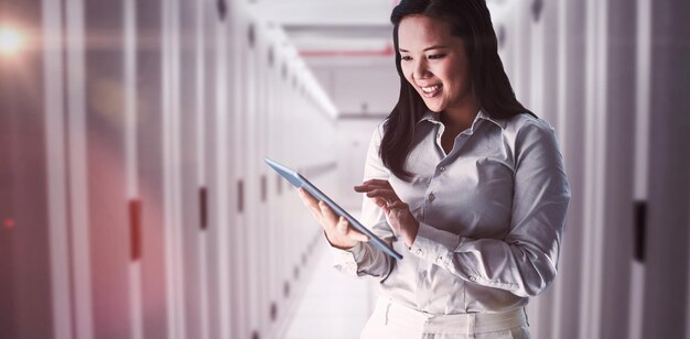 Composite image of smiling businesswoman using tablet