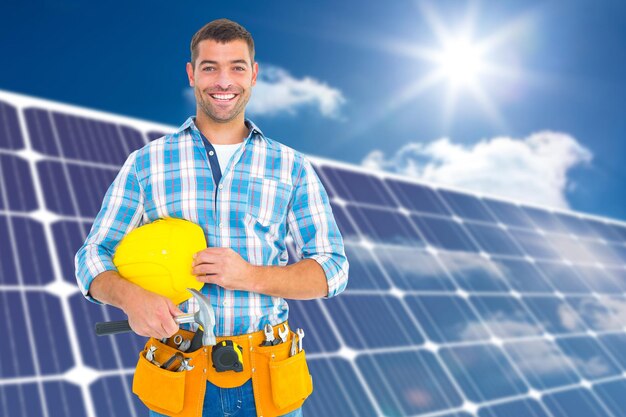 Composite image of smiling handyman holding hardhat and\
hammer